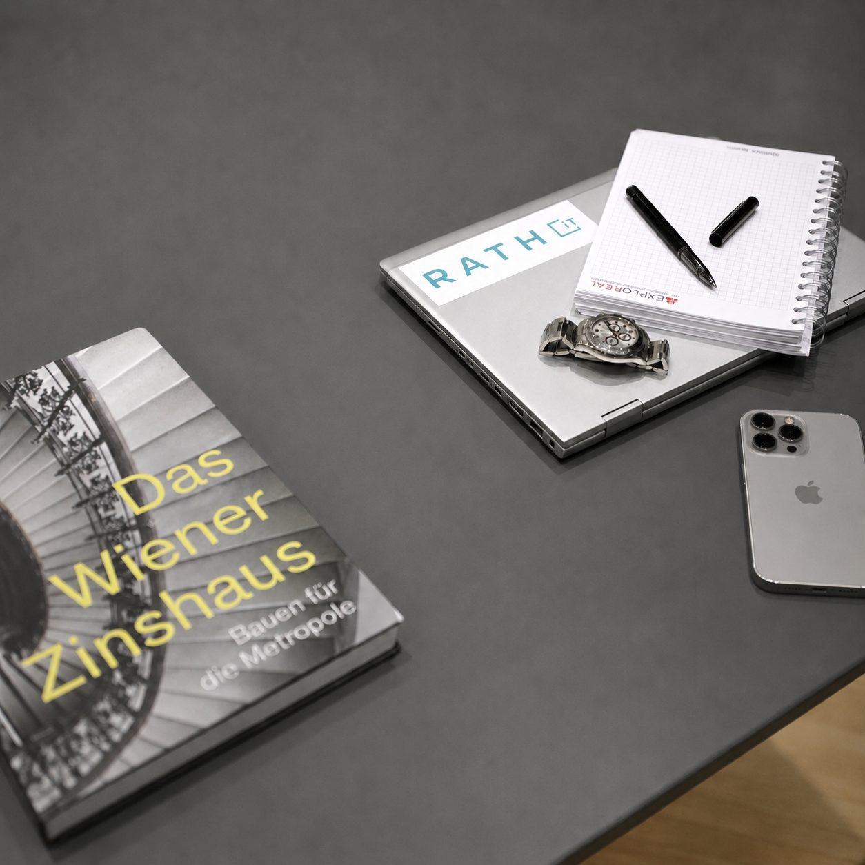 Arbeitsplatz mit Laptop, Notizblock und dem Buch „Das Wiener Zinshaus“